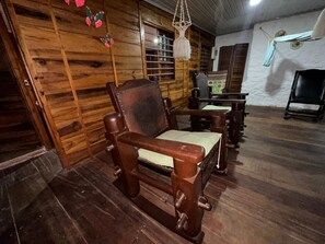 A wooden interior with a sofa, a hanging macrame light, and a wooden wall. - Beachfront cottage- north of cartagena-ideal for family-comfort and relaxation (Cartagena de Indias)
