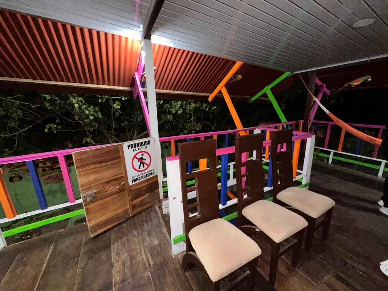 Een overdekt terras met kleurrijke reling en een bordje dat een verboden gebied aangeeft.