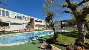 Un hôtel doté d’une piscine, d’un grand arbre et d’une pelouse bien entretenue.