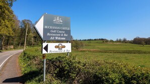 En skylt för restaurangen och baren vid Buchanan Castle Golf Course, med en pil som visar vägen.