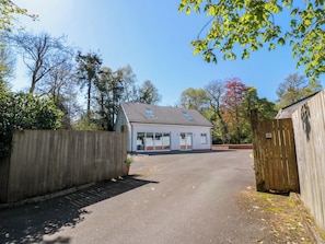 Ein zweistöckiges Gebäude mit Garage, Holzzaun und blauem Himmel.