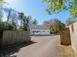 A two-story building with a garage, a wooden fence, and a clear sky.