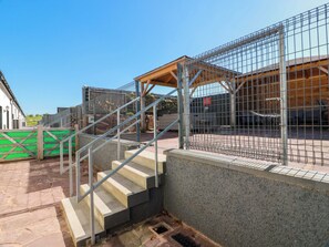 A gated outdoor area with a staircase leading to a covered walkway. - Ledrishmore View (Alexandria)