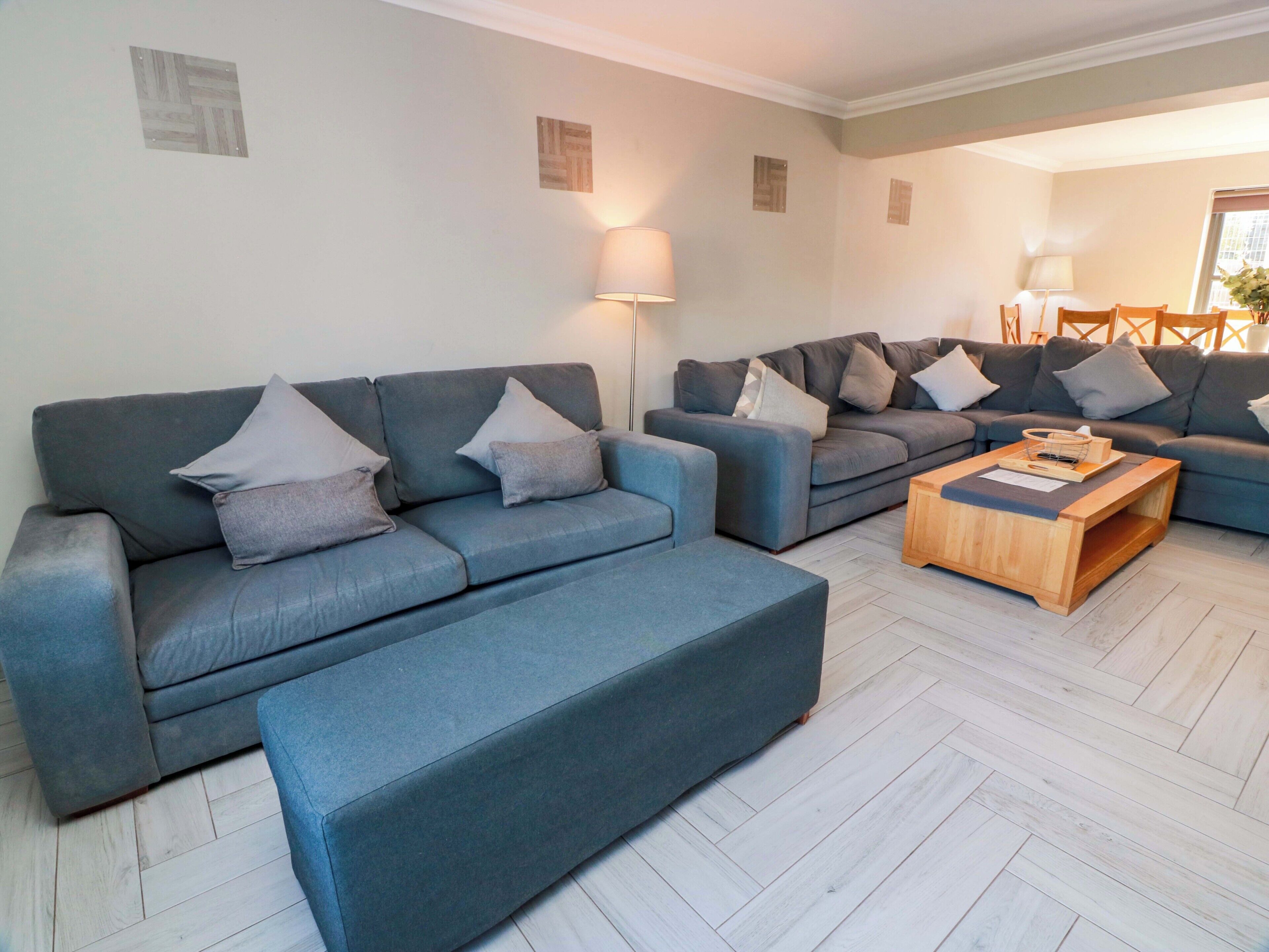 A modern living room with two sofas, a coffee table, and wall-mounted lamps.