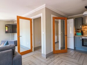 Eine moderne Wohnung mit Wohnzimmer, Küche und einem Flur, der zum Schlafzimmer führt.