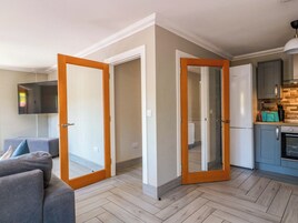 Un apartamento moderno con sala de estar, cocina y un pasillo que lleva a un dormitorio.