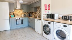 A compact kitchen with a microwave, toaster, and washing machine, a sink, and a fire extinguisher. - Ballaganlea (Alexandria)