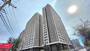 A high-rise building with multiple floors, a flat facade, and a corner entrance. - Hermoso Departamento Estación Central (Santiago)