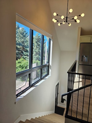 A staircase leading to a second floor with a large window overlooking greenery. - New unique 1-bedroom apartment walking distance to Belgrade downtown and airport (Belgrade)