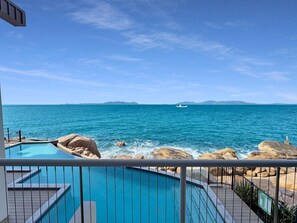 Ein Pool mit Blick auf das Meer und ferne Berge.