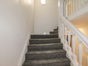 A staircase with carpeted steps and white balusters. - 47 Baxtergate (Whitby)