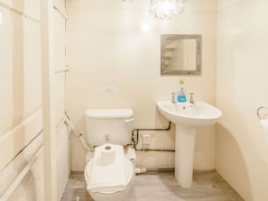 A small, clean bathroom with a toilet, sink, and mirror. - The Anchorage (Whitby)