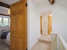 Una habitación con puerta de madera, un radiador, una ventana y una cama.