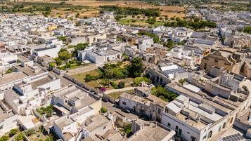 An aerial view of a densely packed urban area with numerous buildings, narrow streets, and some greenery.
