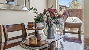 Ein Esstisch mit Blumen in einer Vase, einem gewebten Korb und einem Holztablett.