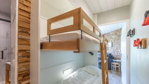 Un letto a castello con testiera in legno, materasso bianco e comodino.