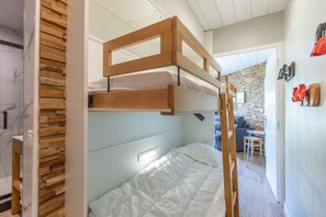 A bunk bed with a wooden headboard, a white mattress, and a bedside table. - Le Nid des Cimes - Proche de la navette des pistes (Barèges)