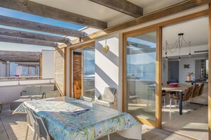 Ein modernes Interieur mit Essbereich, großem Fenster und Blick ins Freie.