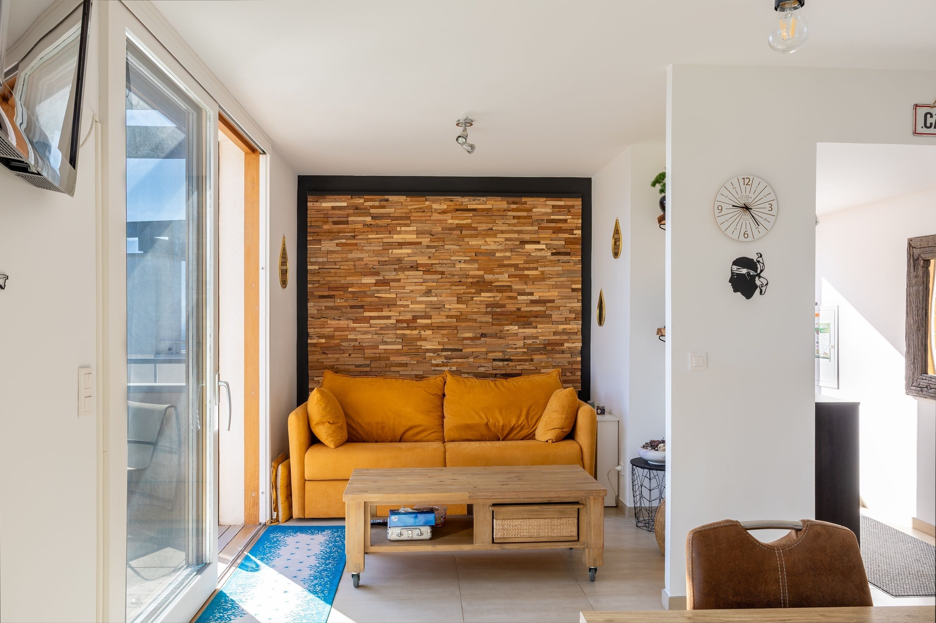 A living room with a sofa, coffee table, and a wall clock.