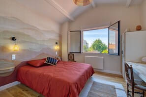 Ein Schlafzimmer mit Bett, Fenster, Stuhl und Heizkörper.
