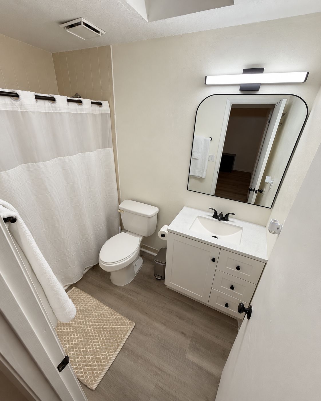 Une salle de bain moderne équipée de toilettes, d’un lavabo et d’un miroir.