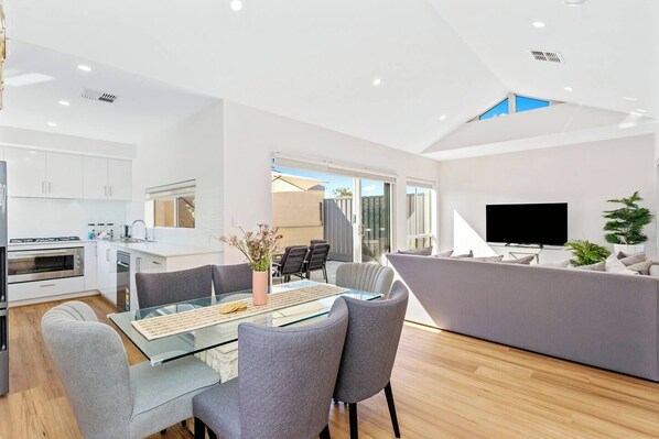 A modern apartment with a kitchen, dining area, and living room.
