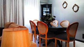 A dining area with a table and chairs, a lamp, and a decorative vase.
