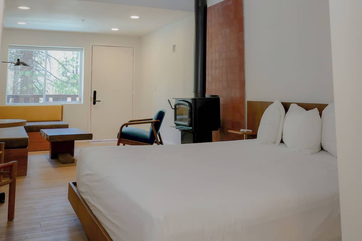 Una habitación de hotel moderna con una cama grande, un escritorio, una silla y un televisor.