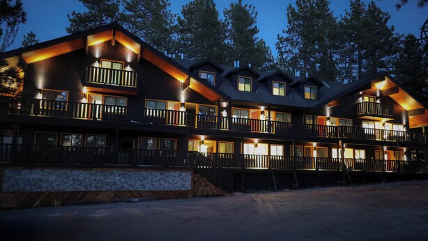 A multi-story lodge with balconies, large windows, and a stone facade. - Arkouda House (Big Bear Lake)