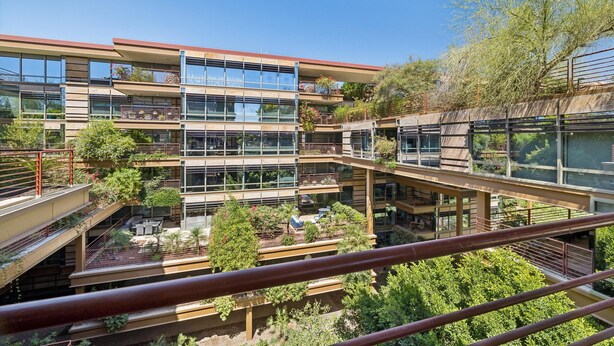 A multi-story building with balconies, large windows, and outdoor greenery. - 4 MONTH MINIMUM RENTAL-Cozy 1 bedroom and 1.5 bath in the Iconic Optima ! (Scottsdale)