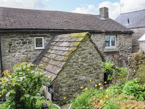 A stone house with a sloped roof, a chimney, and a small window. - Bargate Cottage (Hope Valley)