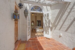 An open doorway leading to a room with a white door, a ceiling fan, and a window with a view of palm trees. - Spanish Beauty in upscale Coconut Grove, Miami! Best location on Elegant St. (Miami)
