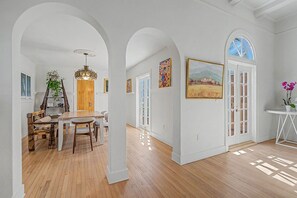A spacious room with wooden flooring, white walls, and a dining area with a wooden table and chairs. - Spanish Beauty in upscale Coconut Grove, Miami! Best location on Elegant St. (Miami)