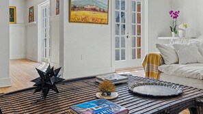 A living room with a coffee table, books, a painting, and a sofa. - Spanish Beauty in upscale Coconut Grove, Miami! Best location on Elegant St. (Miami)