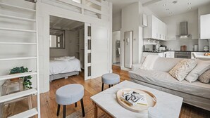 Un espacio habitable moderno y de concepto abierto con cama, sofá y zona de comedor.