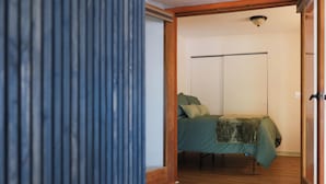Un dormitorio con cama, una escalera de madera y un armario.