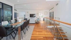 Un espace de vie moderne comprenant un coin repas, une cuisine et un escalier.