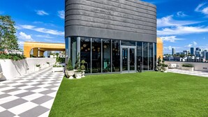 Een modern gebouw met een gebogen gevel, grote glasramen en een zwart-wit schaakbordvloer.