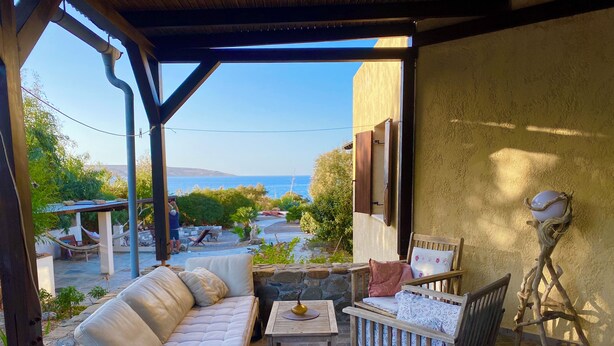 Un patio abrité avec un canapé, des fauteuils et une table.