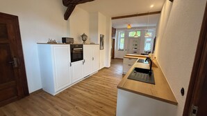 Eine moderne Küche mit weißen Schränken, einem eingebauten Ofen und einer Holz Arbeitsplatte.