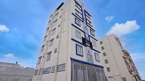 A multi-story building with a series of windows and a central decorative element. - Classic Airport Stay (Nelamangala)