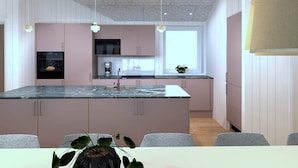A modern kitchen with a central island, pendant lights, and a window providing natural light. - 5 Star Holiday Home in Bogense (Bogense)