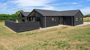 A modern two-story house with a flat roof, large windows, and a covered outdoor area. - 5 Star Holiday Home in Bogense (Bogense)
