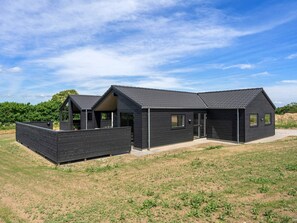 A modern two-story house with a flat roof, large windows, and a covered outdoor area. - 5 Star Holiday Home in Bogense (Bogense)