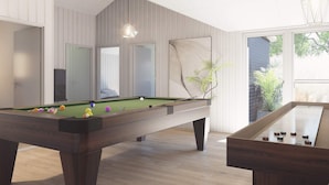 A pool table in a modern room with wooden flooring, a large mirror, and a view of the outdoors. - 5 Star Holiday Home in Bogense (Bogense)