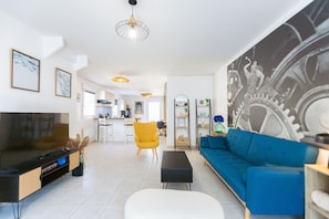 Een moderne woonkamer met een televisie, bank en salontafel.