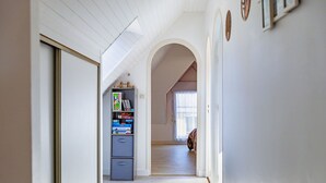 A narrow hallway with a bookshelf, a door, and a window. - Townhouse with garage, Saint-Quay-Portrieux (Saint-Quay-Portrieux)