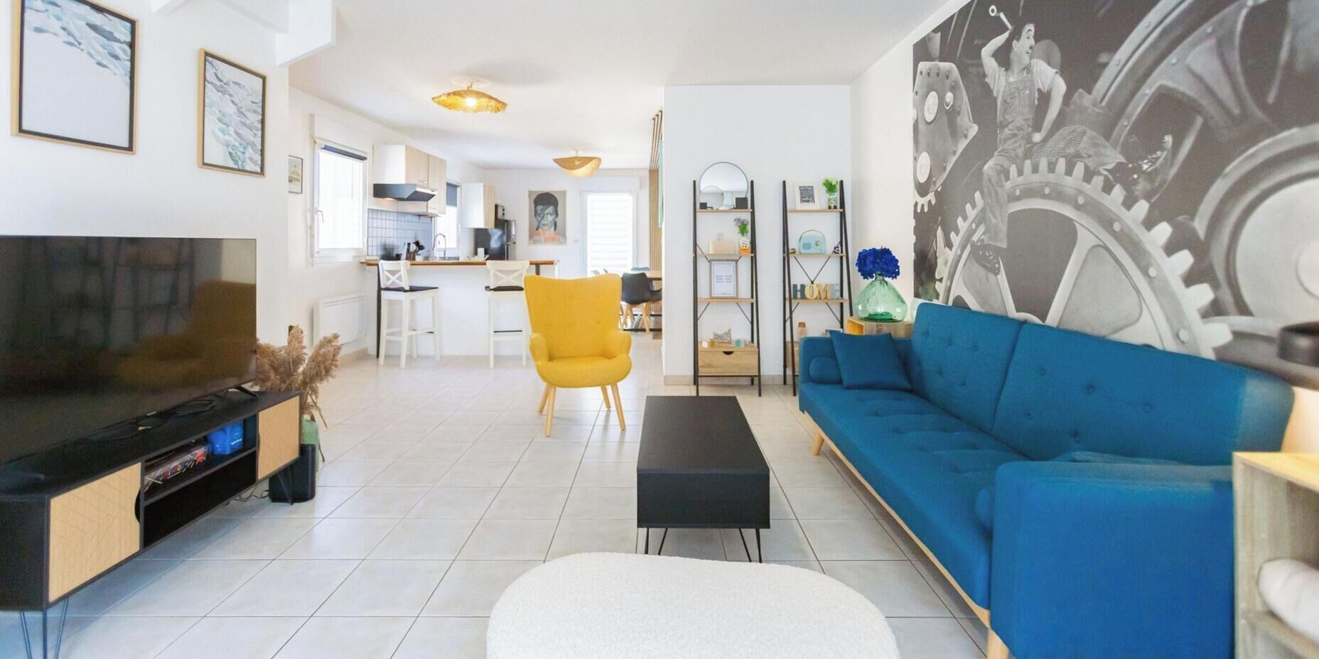 A modern living room with a TV, sofa, and yellow chair.
