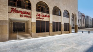 A hotel facade with arched windows and a clear entrance. - Hampton By Hilton Madinah Central District (Madinah)