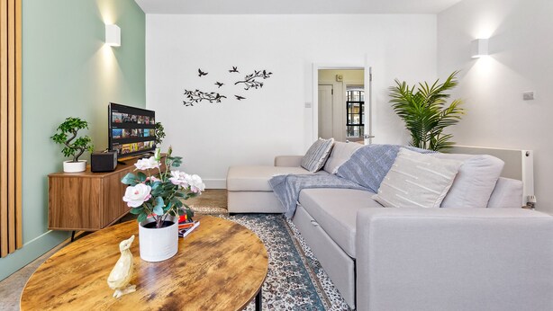 A modern living room with a sofa, coffee table, and decorative plants. - 3 -Berry Street EC1V (London)